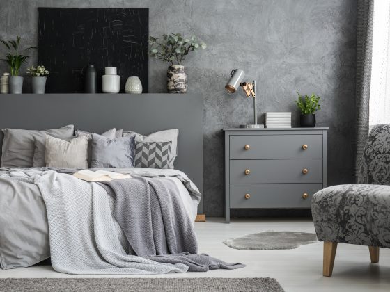 Déco commode chambre grise avec lampe métallique, plantes et livres