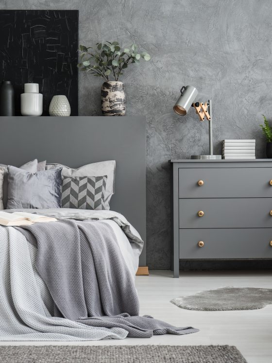 Déco commode chambre grise avec lampe métallique, plantes et livres