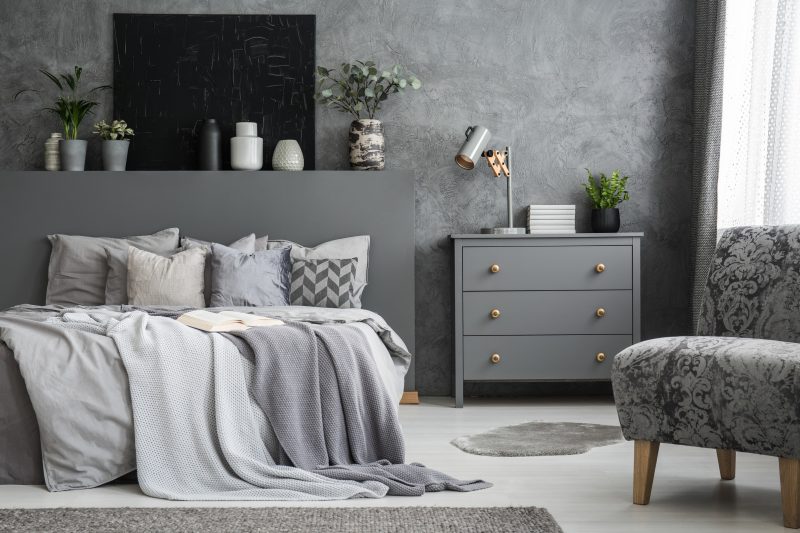 Déco commode chambre grise avec lampe métallique, plantes et livres