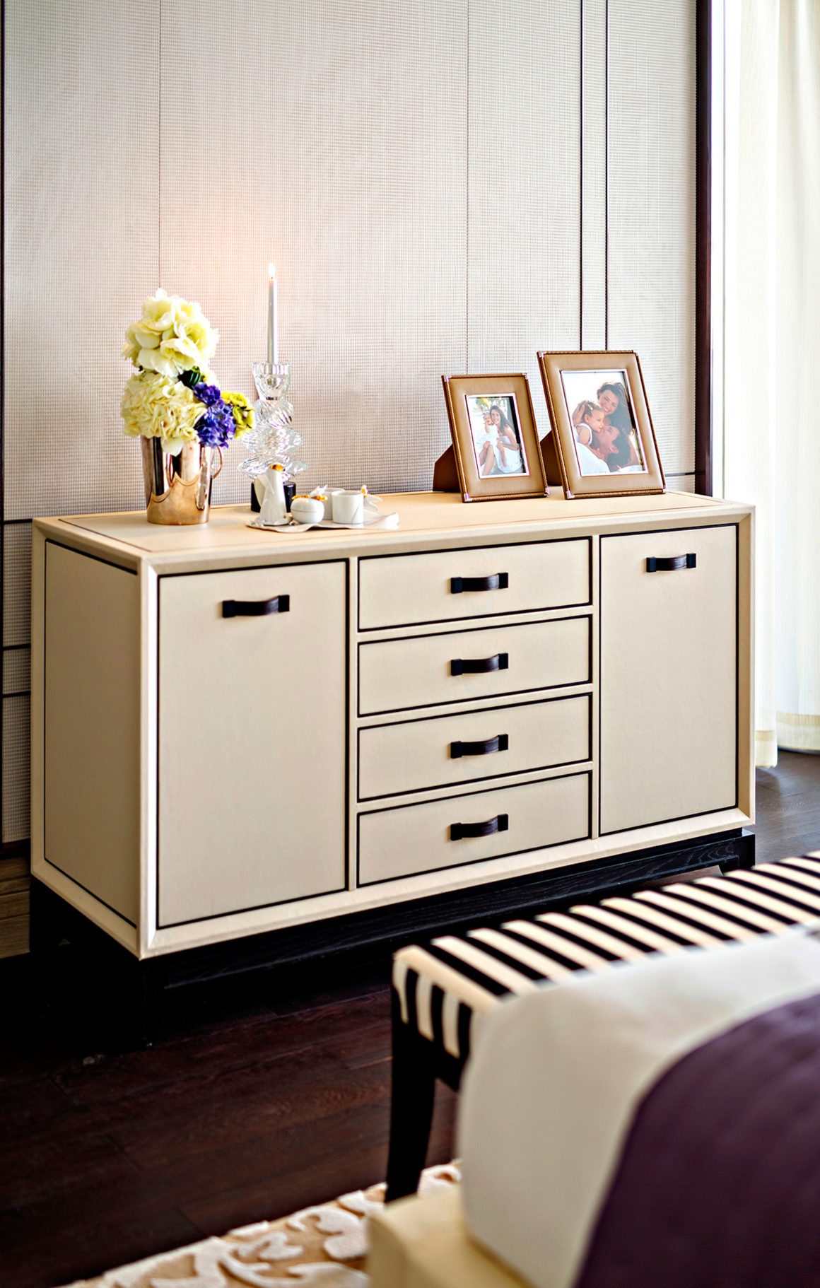 Décoration commode chambre avec vase incluant fleurs blanches/bleues, candélabre et cadres photos