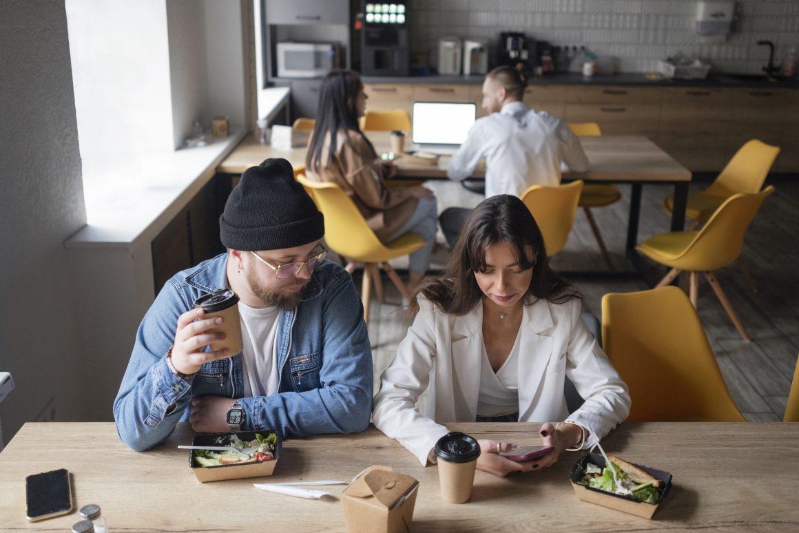 Salle de restauration d'une entreprise équipée et aménagée avec tables en bois et chaises jaunes