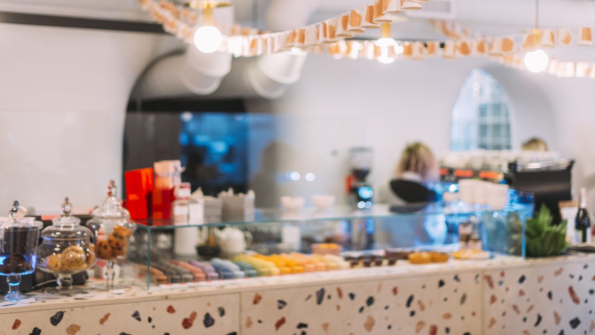Comptoir terrazzo incluant macarons colorés, bocaux, avec lumières chaleureuses