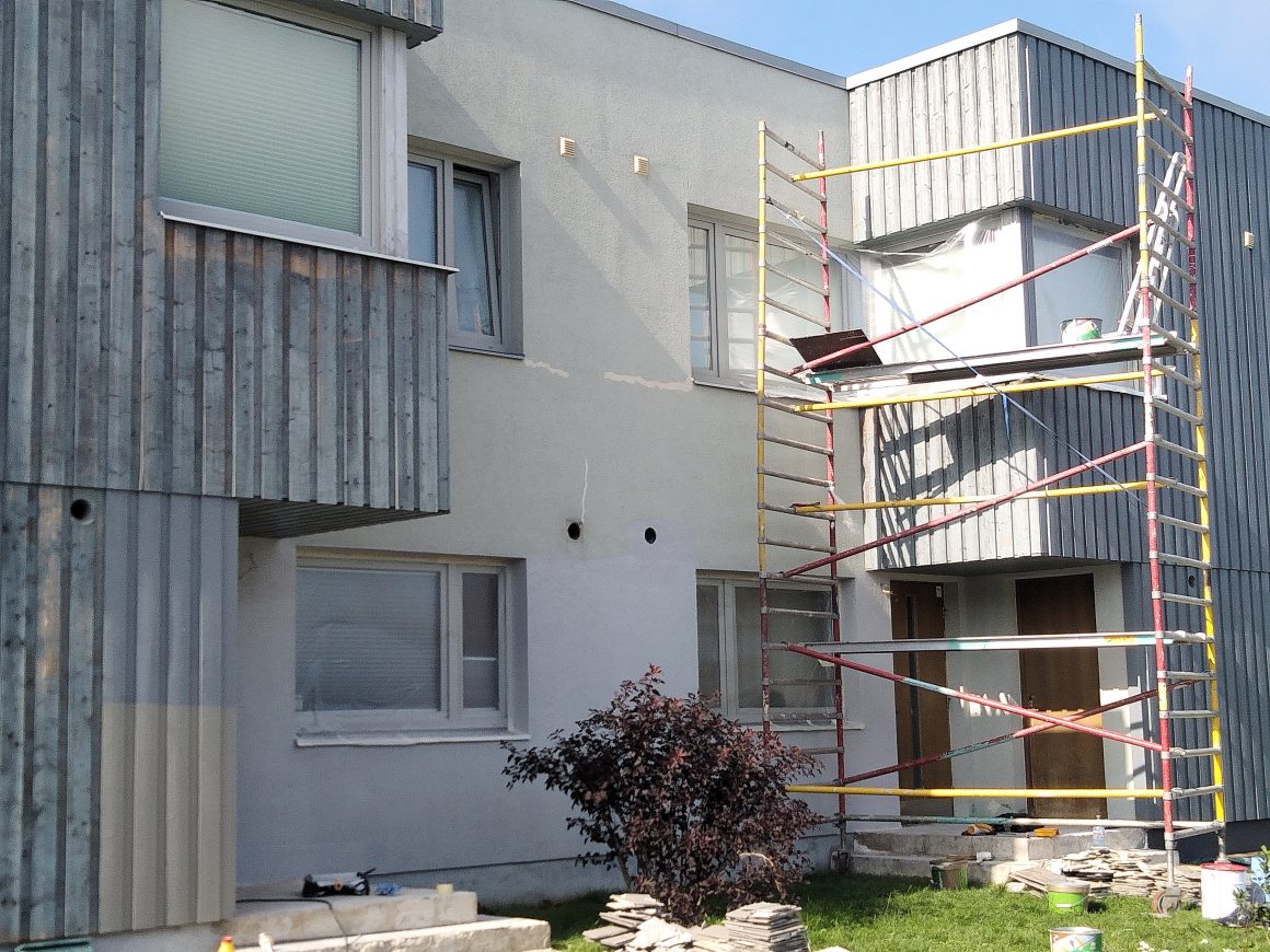 Maison en rénovation : échafaudage, bardage en bois, et outils de construction