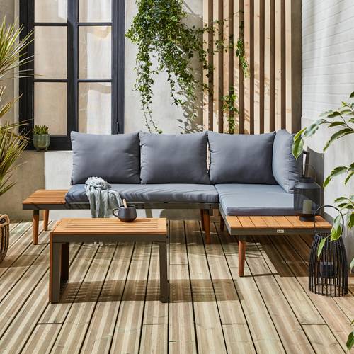 Terrasse en bois incluant canapé d'angle gris foncé avec table basse en bois, lanterne noire et plantes