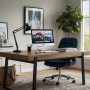 Espace de travail moderne : grand bureau en bois, chaise, lampe plante, commode blanche et tapis