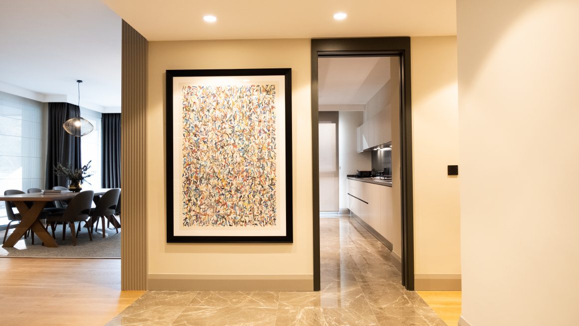 Hall d'entrée moderne avec sol en marbre et grande œuvre encadrée
