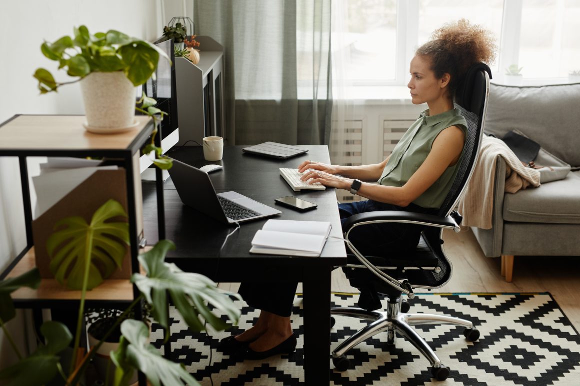 Femme travaillant dans un bureau à domicile incluant chaise, tapis plantes et déco épurée