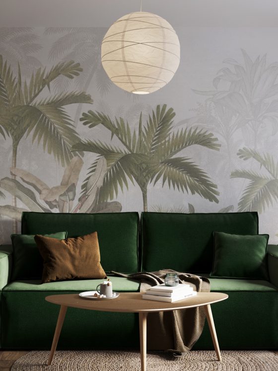 Habillage mur salon avec papier peint à motif tropical, canapé vert, table basse, étagères et lampe