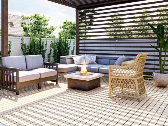Terrasse moderne en bois : pergola, canapé d'angle, fauteuil en rotin, table basse et plantes