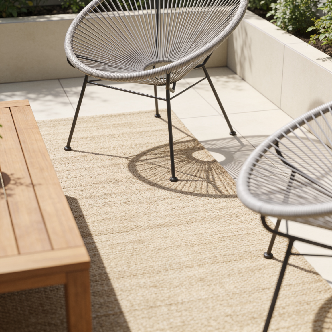 Espace extérieur ombres de soleil, incluant deux fauteuils gris, table en bois et tapis beige