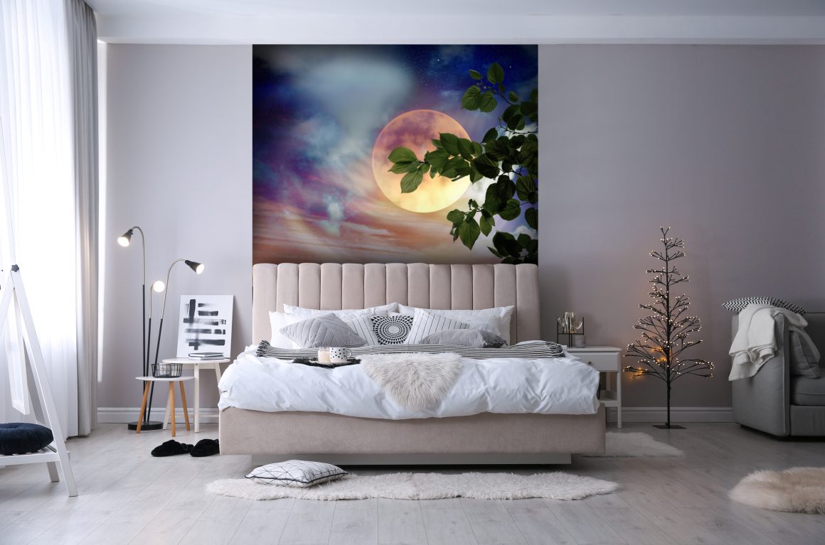 Lit beige moelleux, grande fresque lunaire colorée, lumière douce et décor minimaliste