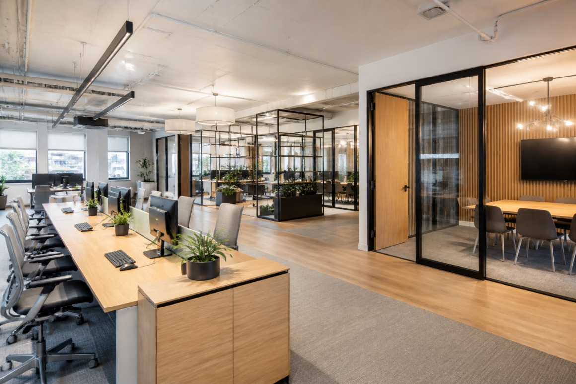Aménagement d'entreprise avec espace open space, plantes et salles vitrées pour réunions