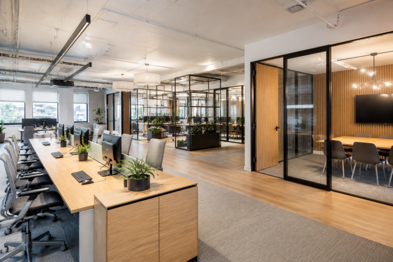 Aménagement d'entreprise avec espace open space, plantes et salles vitrées pour réunions
