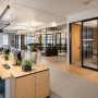 Aménagement d'entreprise avec espace open space, plantes et salles vitrées pour réunions