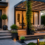 Aménagement terrasse devant maison éclairée avec pergola, plantes suspendues et salon