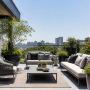 Aménagement d'une terrasse avec grandes jardinières, canapé, fauteuils, table basse et tapis