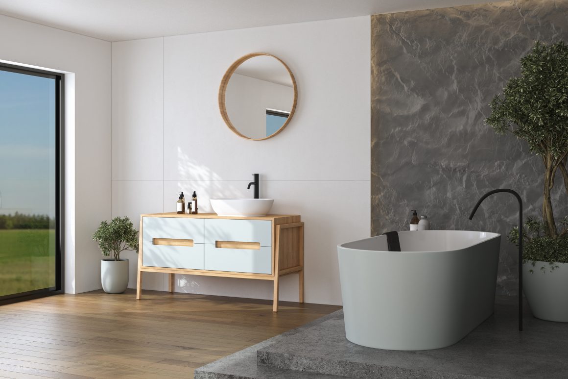 Salle de bain lumineuse : baignoire ovale, meuble lavabo en bois, miroir, plantes et grande fenêtre