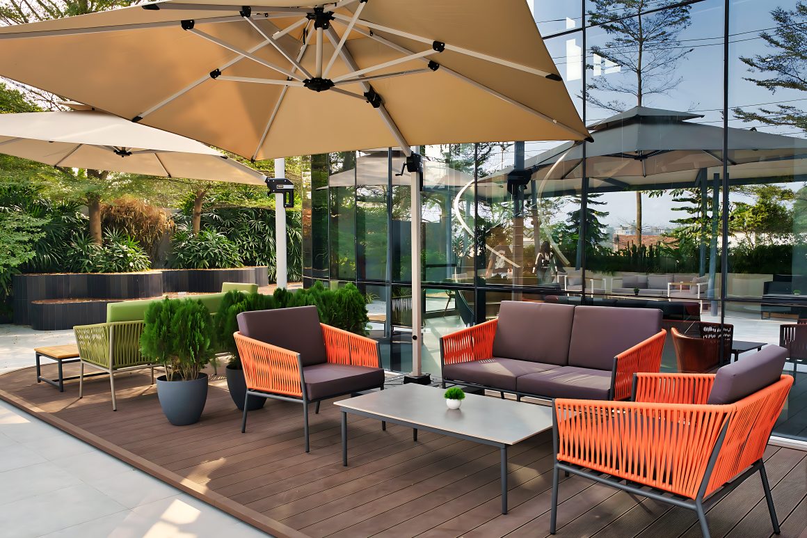 Aménagement terrasse professionnelle avec fauteuils colorés, tables basses, parasols et plantes