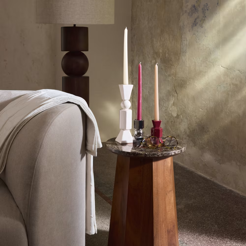 Intérieur avec mur texturé, canapé beige, table en bois incluant bougeoirs colorés
