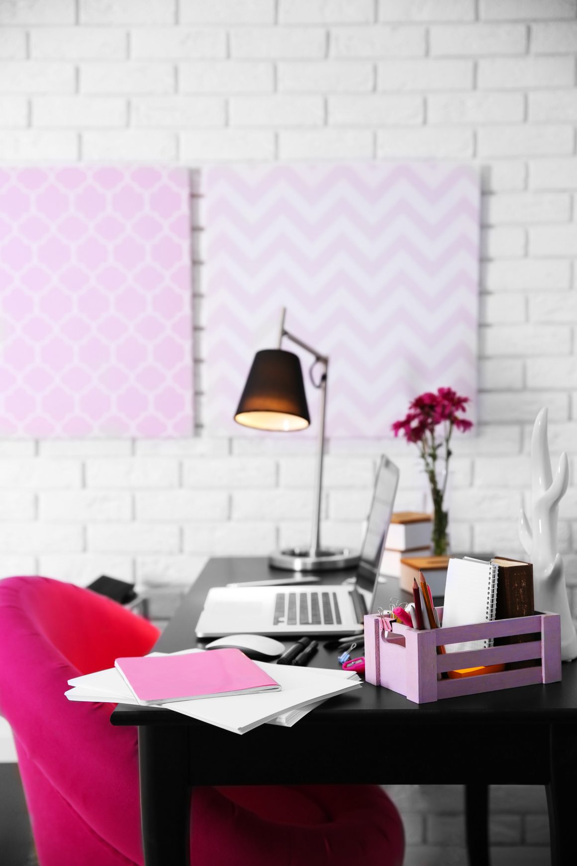 Bureau féminin chic : chaise fuchsia, bureau noir, lampadaire et cadres