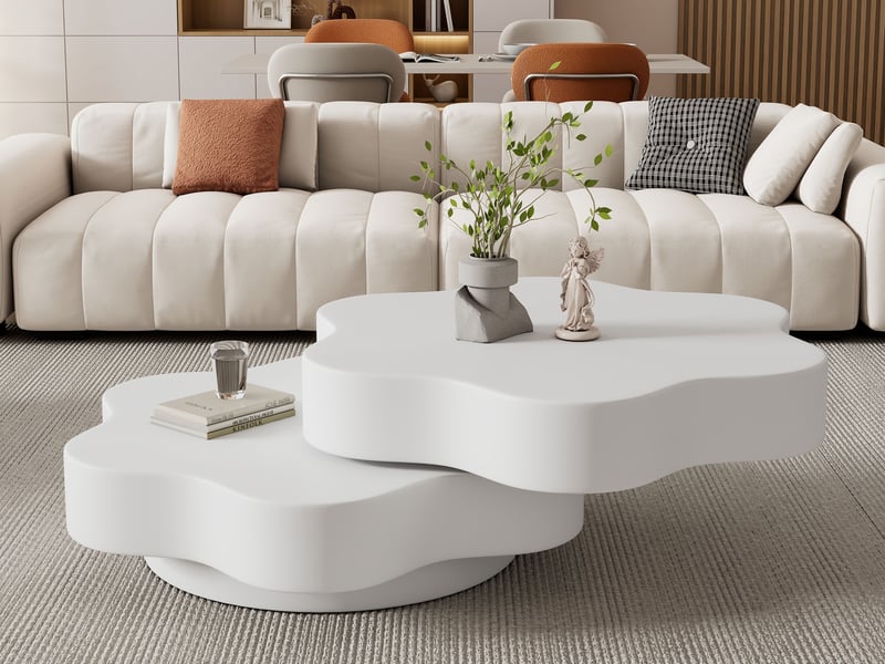 Canapé crème moelleux avec coussins colorés, table basse blanche forme atypique, tapis et plante