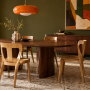 Séjour aux tons verts doté d'une table ovale et de sièges clairs